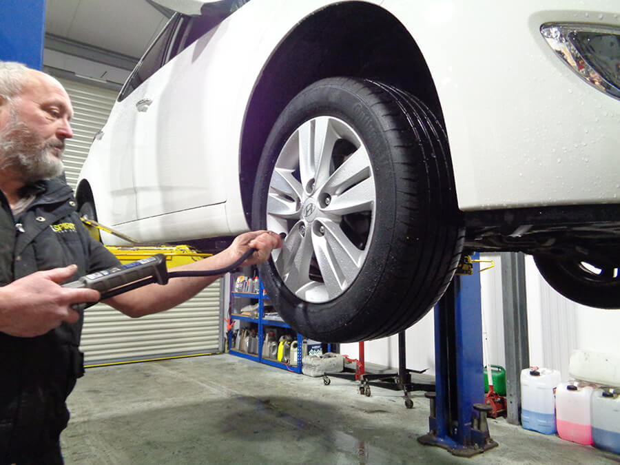 A mechanic working on a car's tyres